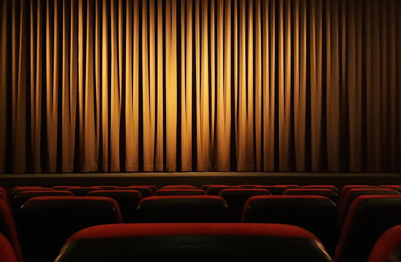 Empty Cinema Seats and Stage Curtain