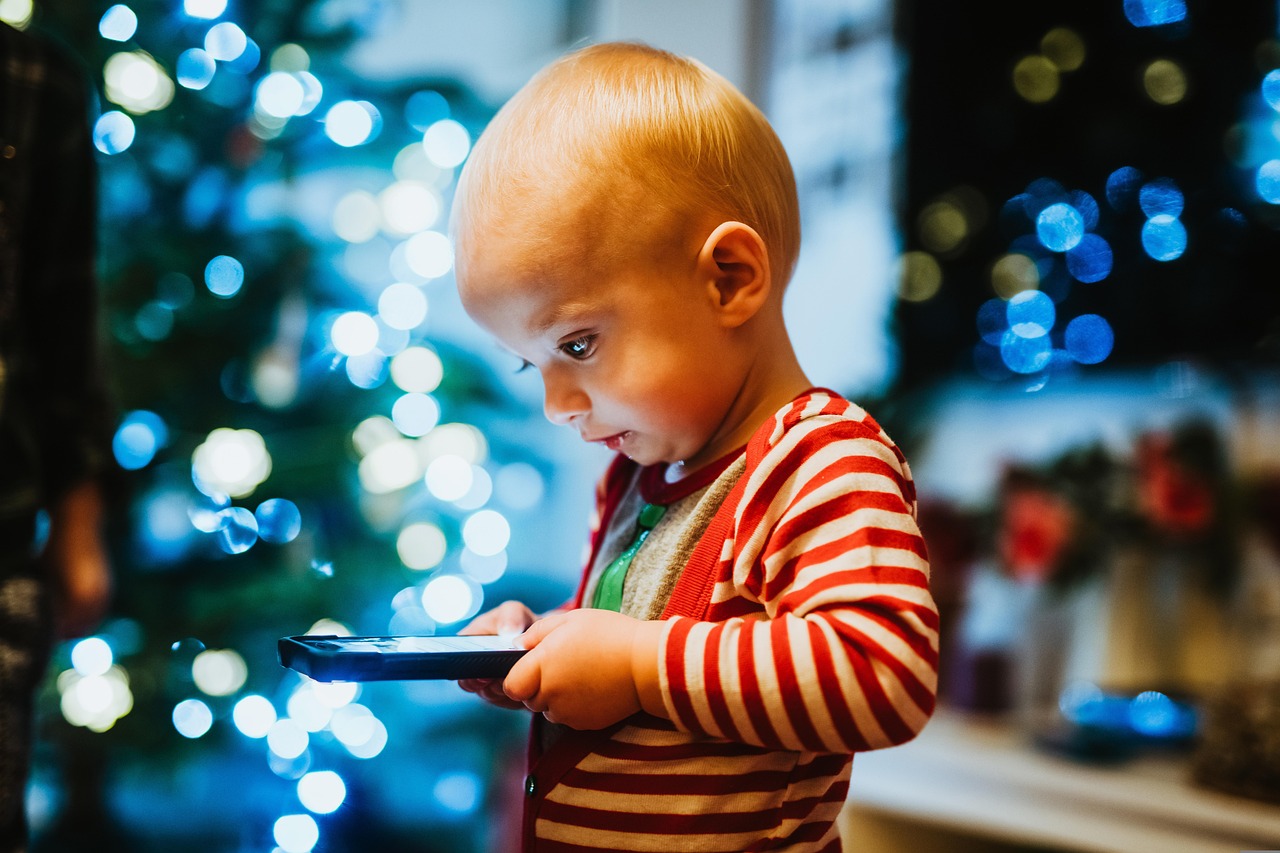 Toddler with Tablet by Christmas Lights
